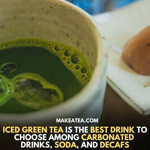 Cold green tea with ice cubes in a white cup