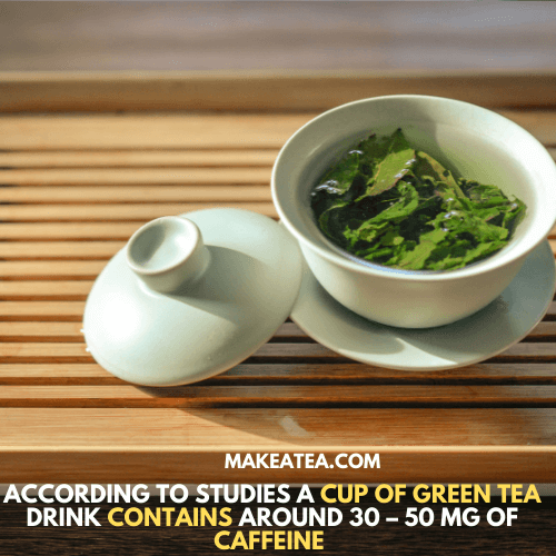 A white cup of green tea with leaves